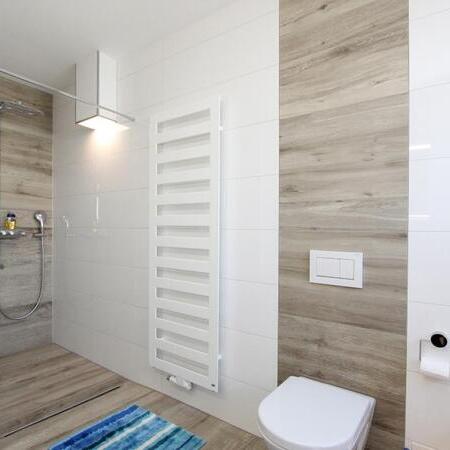 Helles, elegantes Badezimmer mit bodentiefem Duschbereich